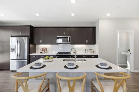 a kitchen with stainless steel appliances granite countertop a stove a refrigerator and a table
