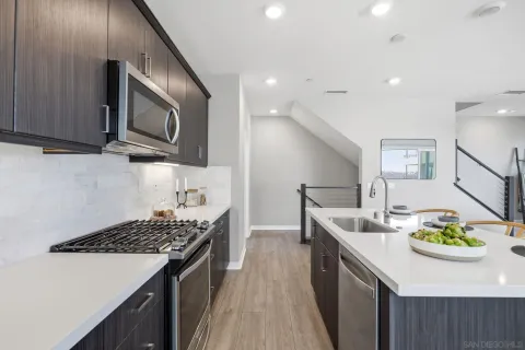 a kitchen with stainless steel appliances granite countertop a sink stove and refrigerator