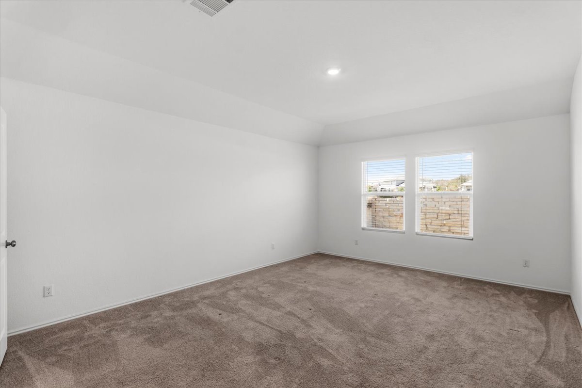 167 Jeffers Kyle, TX 78640 - Photo 22 of 40 Carpeted spare room featuring baseboards and lofted ceiling