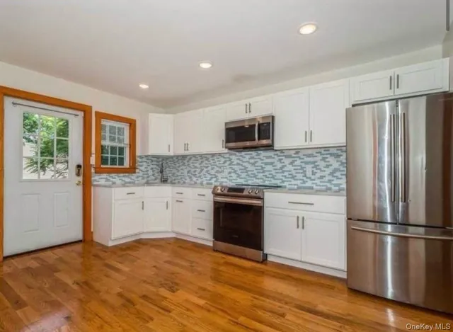 a kitchen with stainless steel appliances granite countertop a refrigerator sink and stove