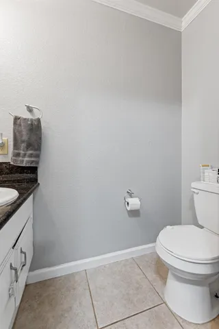 a bathroom with a granite countertop toilet and a sink