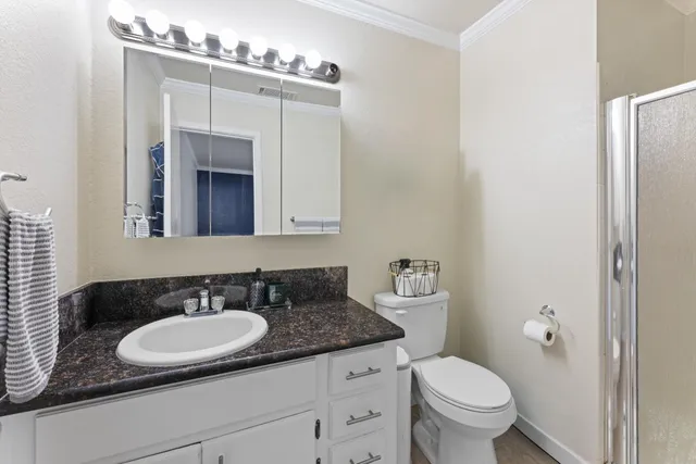 a bathroom with a granite countertop sink a toilet and a mirror