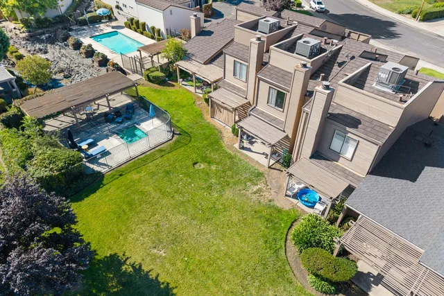 an aerial view of a house with a swimming pool and outdoor seating