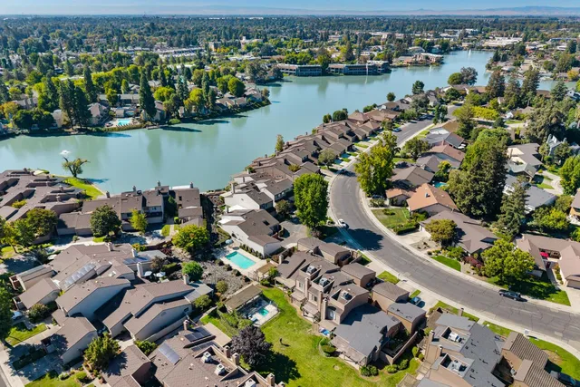 an aerial view of lake and residential houses with outdoor space