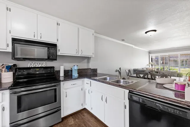 a kitchen with appliances a sink and cabinets