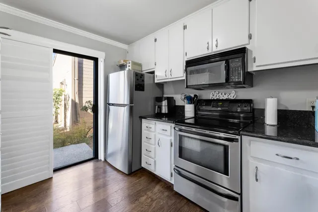 a kitchen with stainless steel appliances white cabinets a stove a refrigerator and a microwave