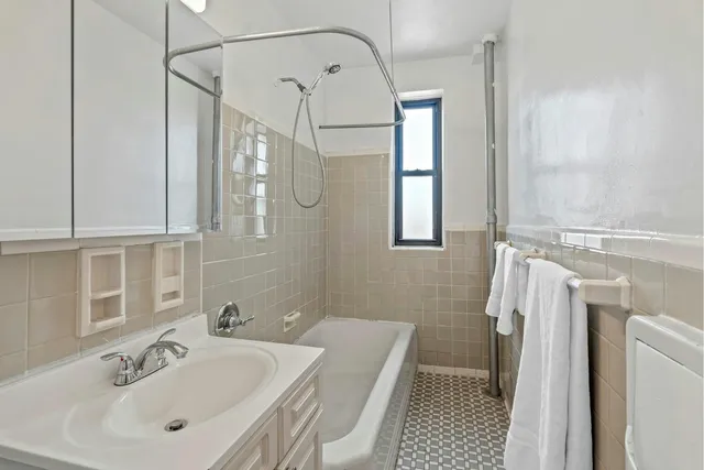 a bedroom with a bed dresser and window