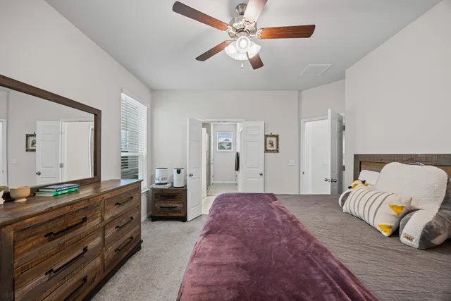 a spacious bedroom with a bed and ceiling fan