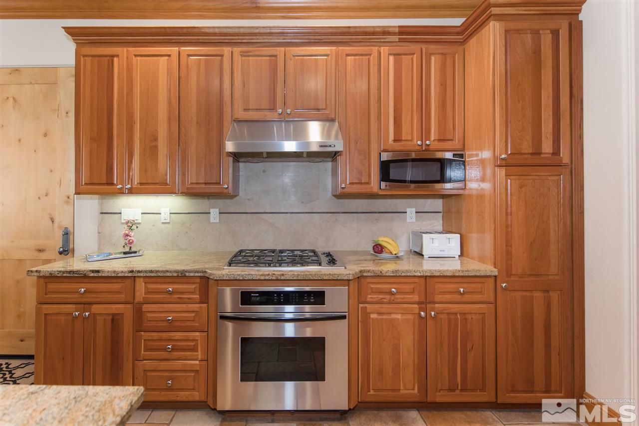 6365 Wetzel Court, Unit MONTRUEX 3 Reno, NV 89511 - Photo 10 of 24 a kitchen with granite countertop wooden cabinets and a stove top oven