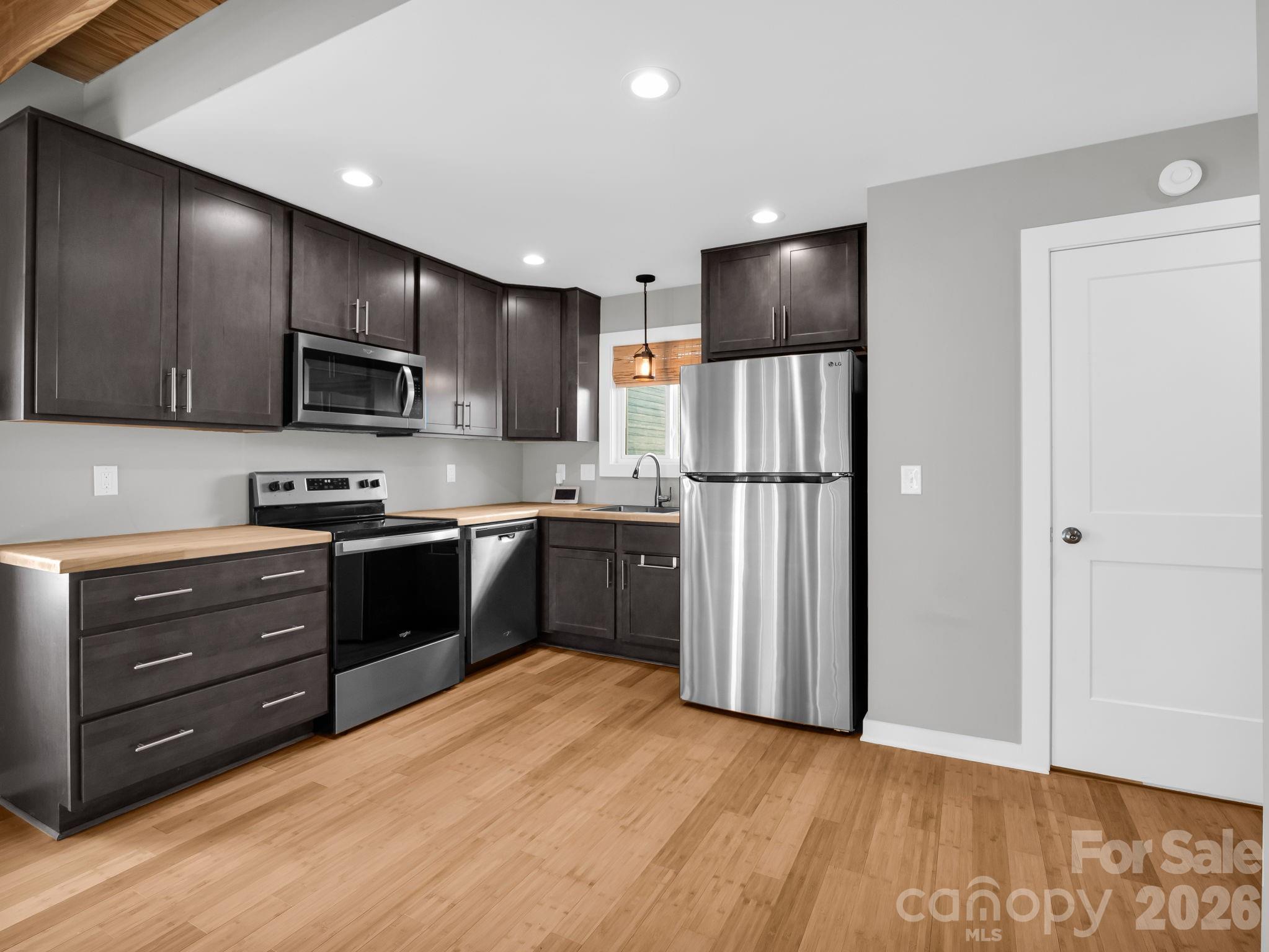 9 East Citra Street Arden, NC 28704 - Photo 3 of 28 a kitchen with granite countertop stainless steel appliances a refrigerator cabinets and wooden floor