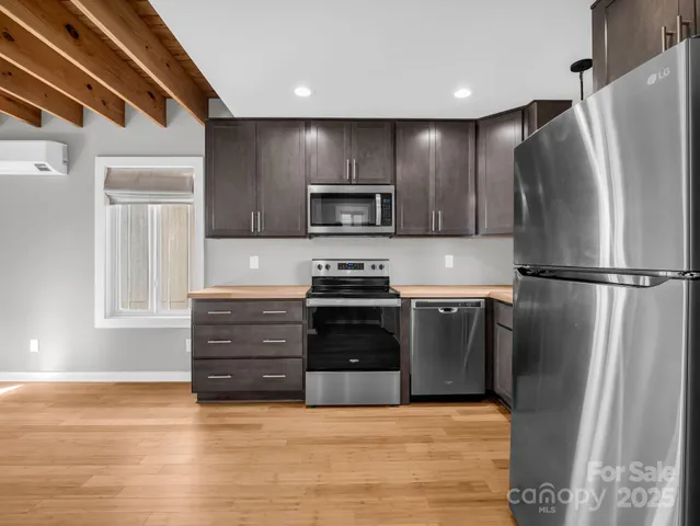 a kitchen with granite countertop a refrigerator and a stove top oven
