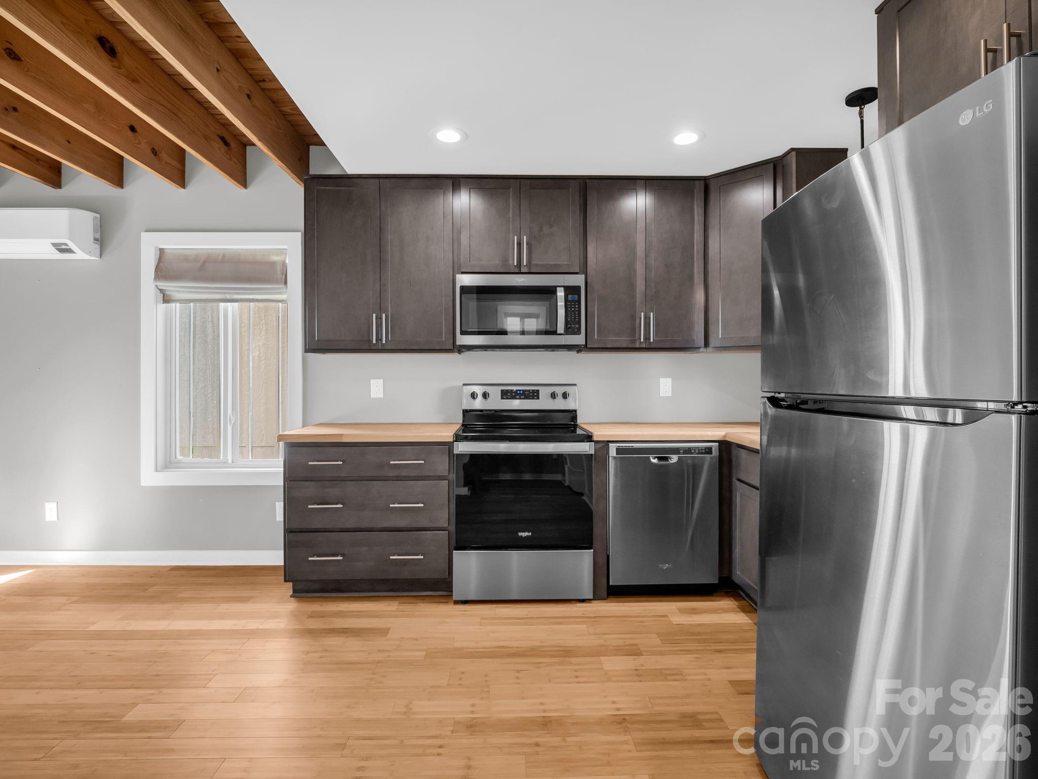 9 East Citra Street Arden, NC 28704 - Photo 7 of 28 a kitchen with granite countertop a refrigerator and a stove top oven