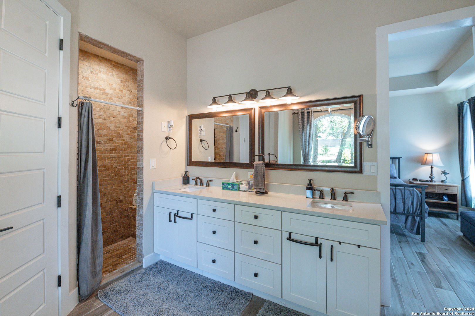 924 Rhinestone Canyon Lake, TX 78133 - Photo 20 of 41 a en suite bathroom with a double vanity sink a mirror and a shower
