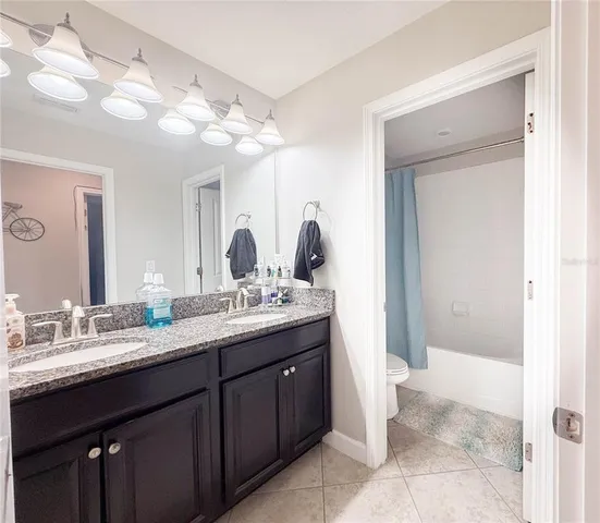 a bathroom with a granite countertop sink a mirror and a shower