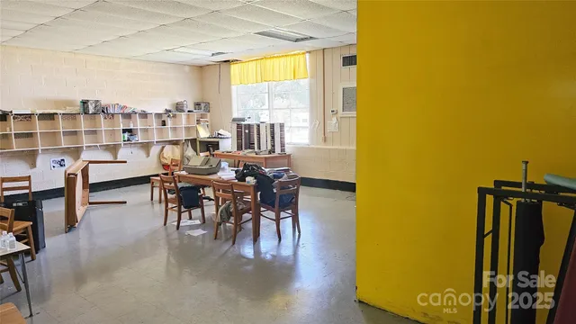 a living room with furniture and a dining table with rug