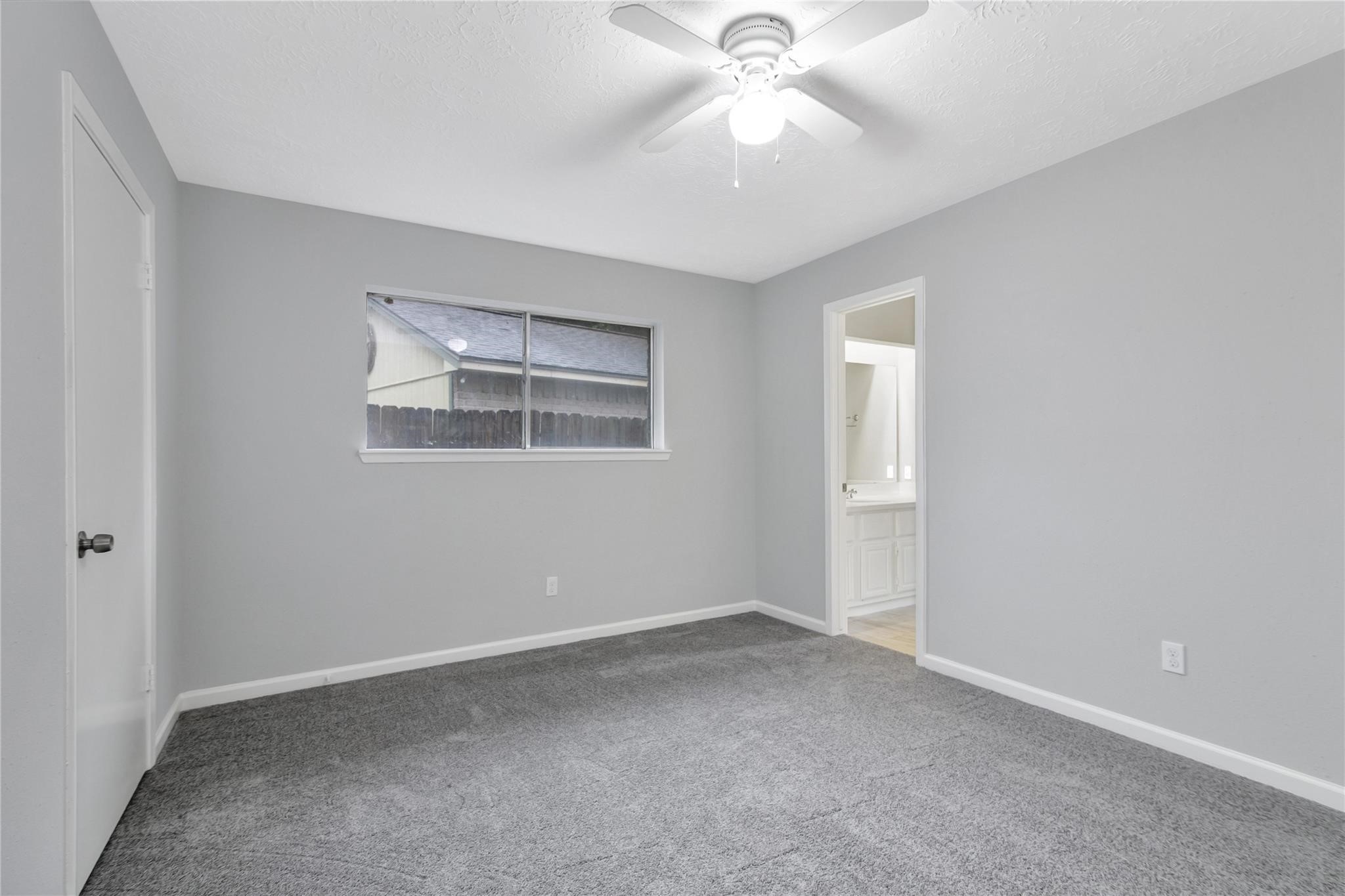 13703 Cologne Drive Houston, TX 77065 - Photo 11 of 32 an empty room with a chandelier fan and windows