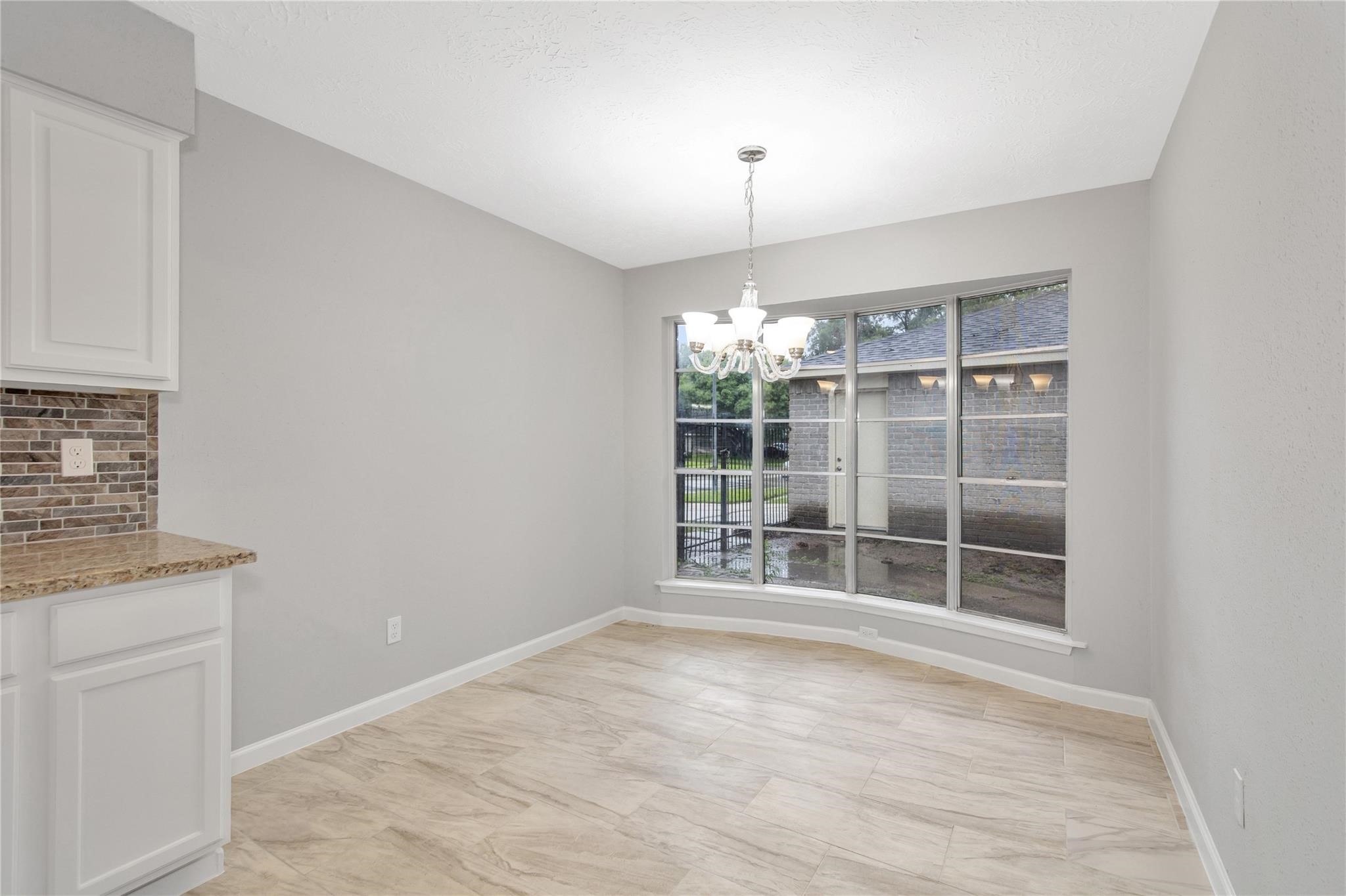 13703 Cologne Drive Houston, TX 77065 - Photo 18 of 32 an empty room with chandelier fan and windows