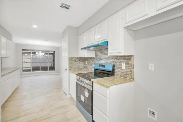 a kitchen with stainless steel appliances granite countertop a stove and a refrigerator
