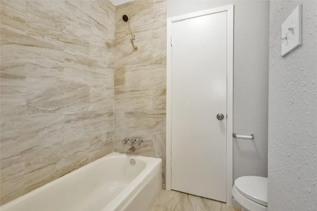 a bathroom with a bathtub and toilet