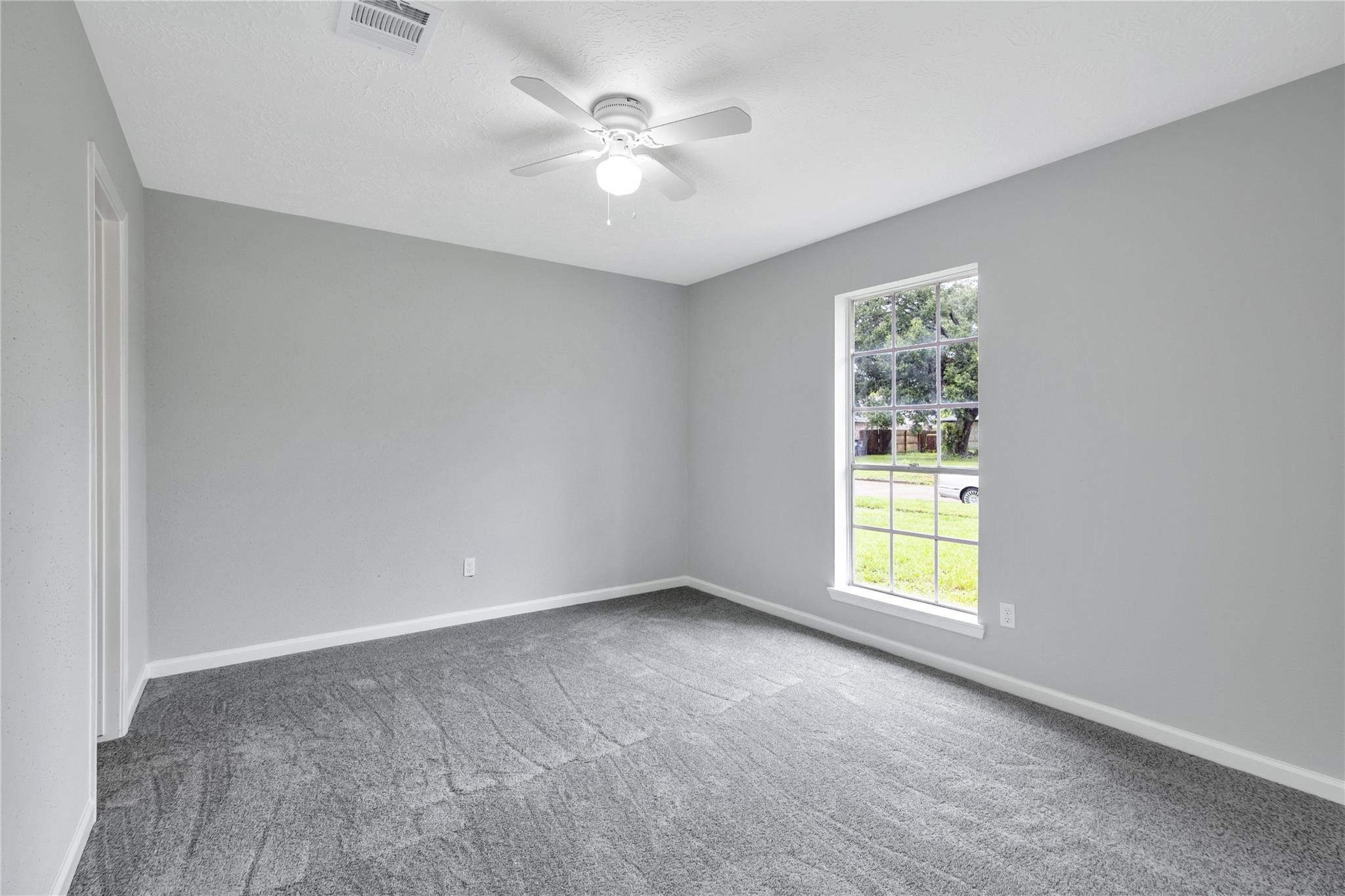 13703 Cologne Drive Houston, TX 77065 - Photo 9 of 32 an empty room with windows and ceiling fan
