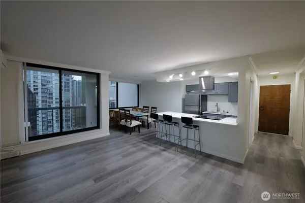 a view of a kitchen with chairs and wooden floor