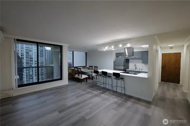 a view of a kitchen with chairs and wooden floor