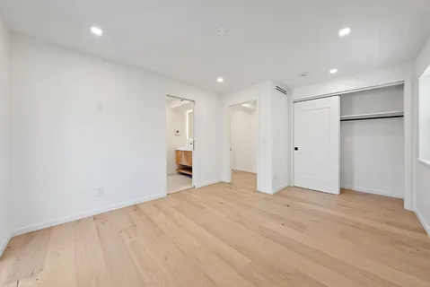 an empty room with wooden floor and window