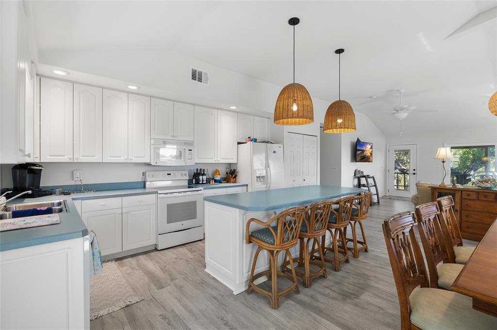 9776 Little Gasparilla Boca Grande, FL 33921 - Photo 20 of 52 a kitchen with stainless steel appliances granite countertop a stove a sink a dining table and chairs with wooden floor