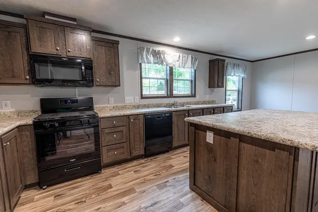 a kitchen with stainless steel appliances granite countertop a stove a sink and a microwave