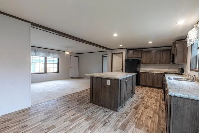 a kitchen with stainless steel appliances granite countertop a stove a sink and a refrigerator