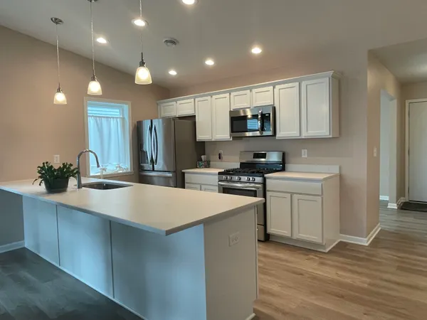 a kitchen with kitchen island a sink stainless steel appliances and cabinets