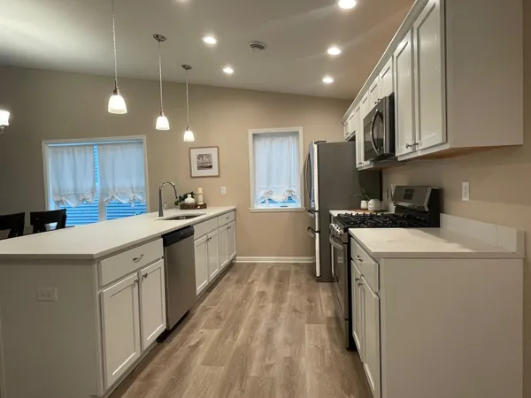 a kitchen with a sink a counter top space stainless steel appliances and cabinets
