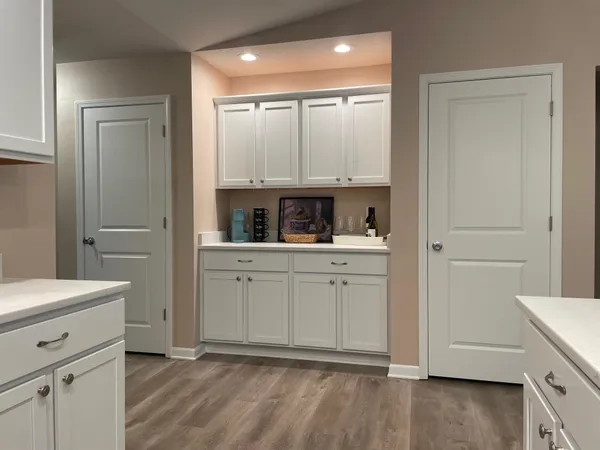 a kitchen with a refrigerator and white cabinets