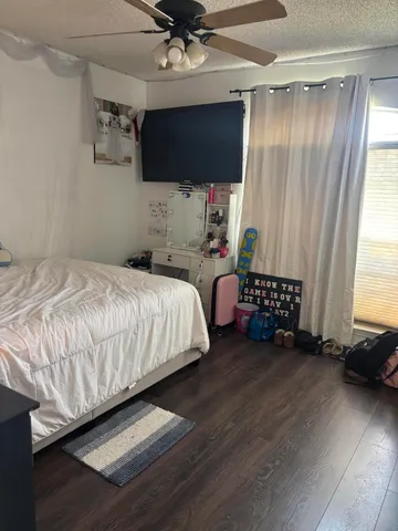 a bedroom with a bed window and a flat screen tv