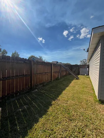 a view of backyard with wooden fence