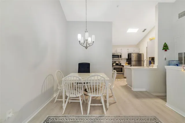 a view of a dining room with furniture and chandelier