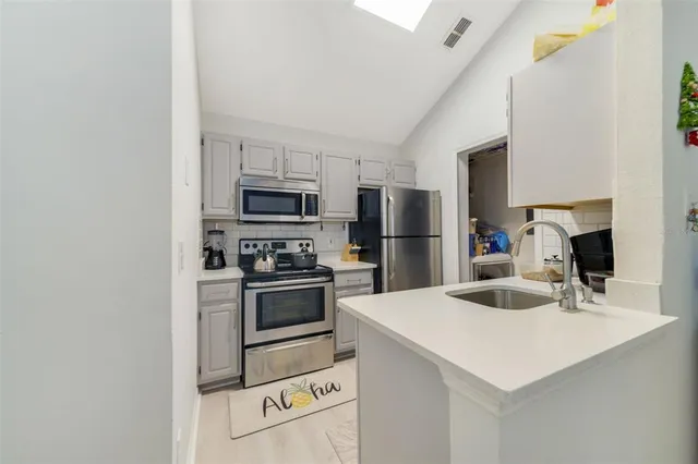 a kitchen with kitchen island a sink appliances and cabinets