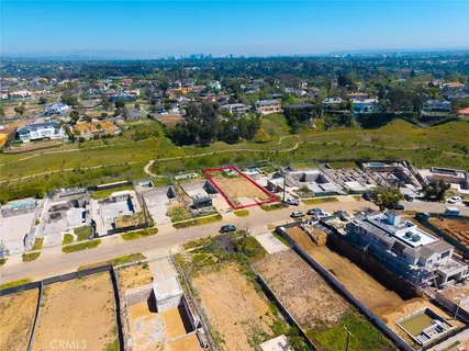 an aerial view of a city with lots of residential buildings ocean and mountain view in back