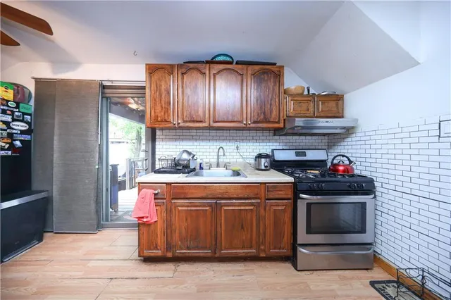 a kitchen with stainless steel appliances granite countertop wooden cabinets a stove and sink