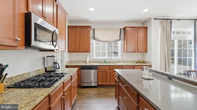 a kitchen with stainless steel appliances granite countertop a sink stove and cabinets