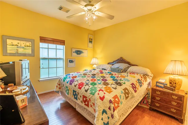 a bedroom with a bed and a flat tv screen on dresser