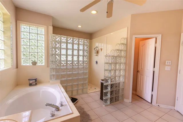 a bathroom with a tub shower and window