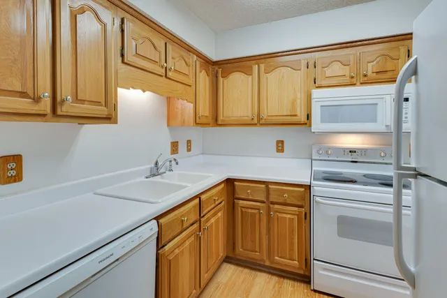 a kitchen with stainless steel appliances granite countertop a sink and cabinets with wooden floor