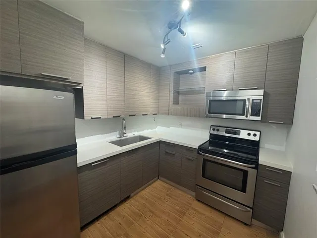 a kitchen with a sink stove and refrigerator