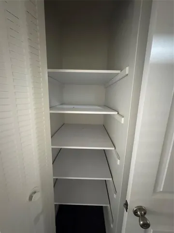 a view of walk in closet with empty racks