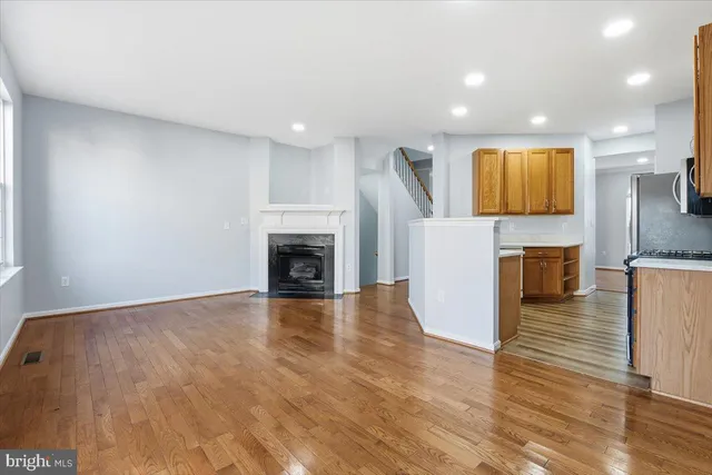 an empty room with wooden floor and fireplace
