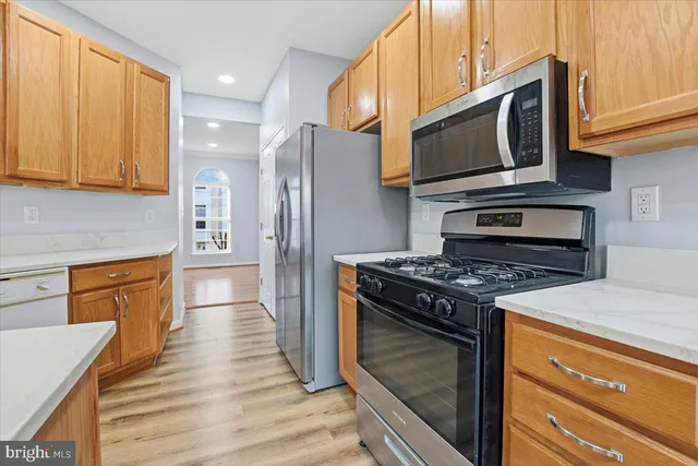 a kitchen with stainless steel appliances granite countertop a stove microwave refrigerator and sink