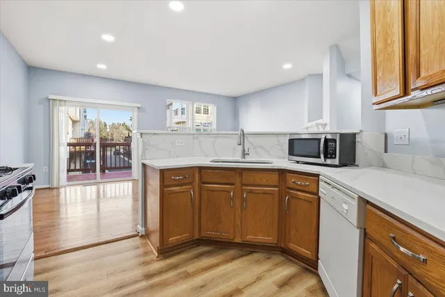 a kitchen with stainless steel appliances granite countertop a sink and dishwasher a stove top oven with wooden floor
