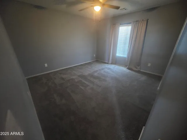 a view of an empty room with wooden floor and windows