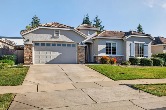 a front view of a house with a yard and trees